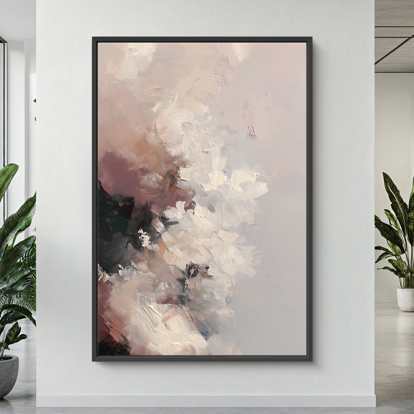 Abstract painting in a black frame on a white wall with plants on either side.