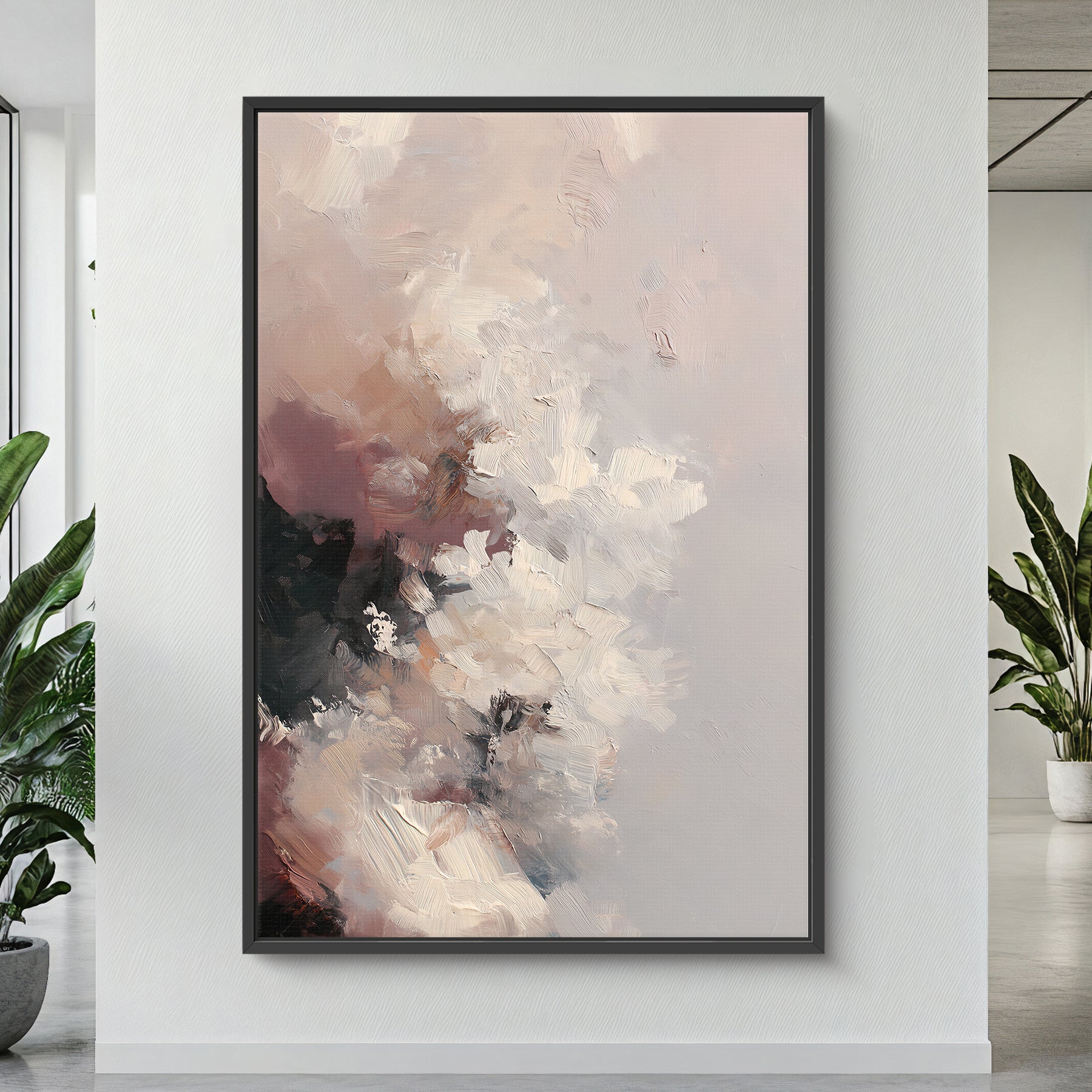 Abstract painting in a black frame on a white wall with plants on either side.